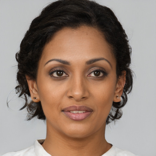 Joyful black young-adult female with medium  brown hair and brown eyes