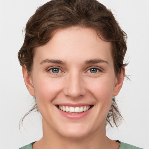 Joyful white young-adult female with medium  brown hair and green eyes