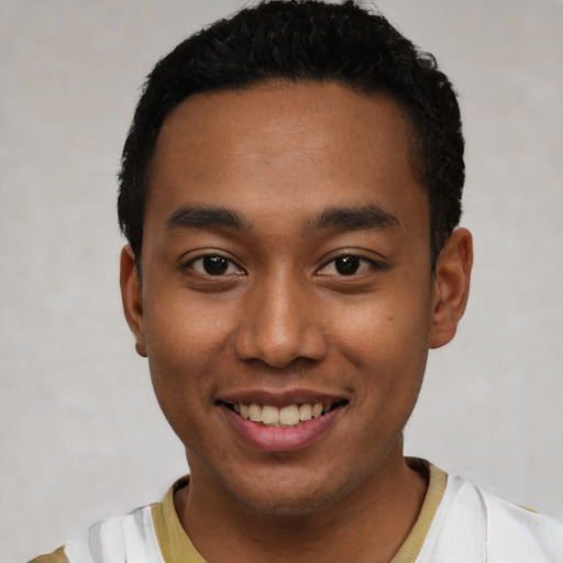 Joyful latino young-adult male with short  black hair and brown eyes