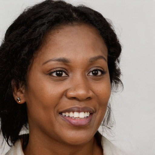 Joyful black young-adult female with long  brown hair and brown eyes