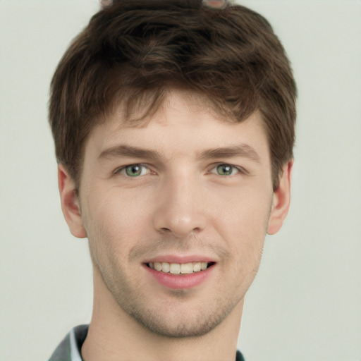 Joyful white young-adult male with short  brown hair and green eyes