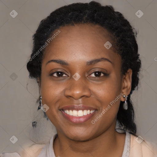 Joyful black young-adult female with long  black hair and brown eyes