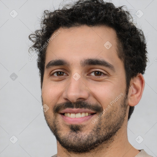 Joyful white young-adult male with short  black hair and brown eyes