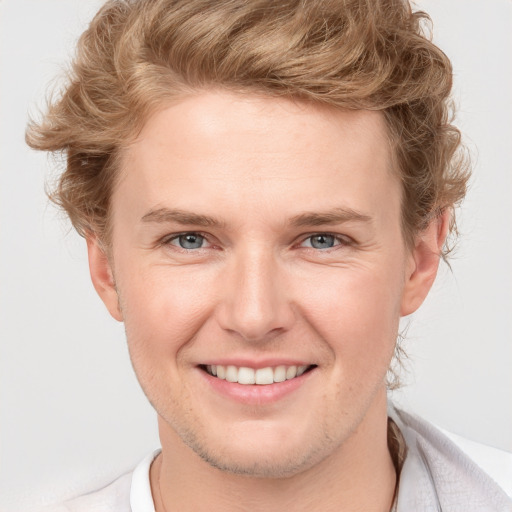 Joyful white young-adult male with short  brown hair and blue eyes