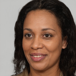 Joyful black adult female with long  brown hair and brown eyes