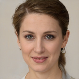 Joyful white young-adult female with medium  brown hair and green eyes