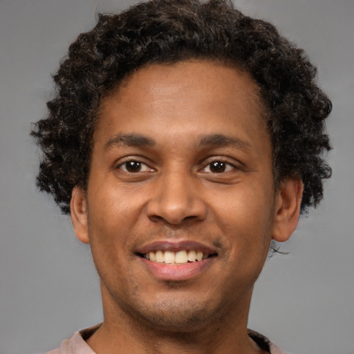 Joyful black young-adult male with short  brown hair and brown eyes
