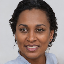 Joyful black adult female with short  brown hair and brown eyes