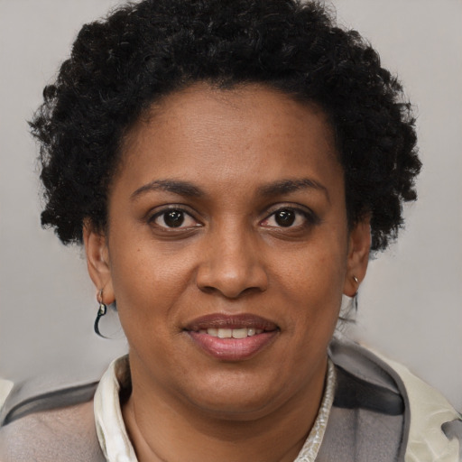 Joyful black adult female with short  brown hair and brown eyes