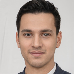 Joyful white young-adult male with short  black hair and brown eyes