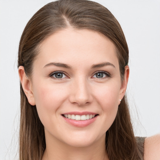 Joyful white young-adult female with long  brown hair and grey eyes