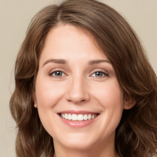 Joyful white young-adult female with long  brown hair and green eyes