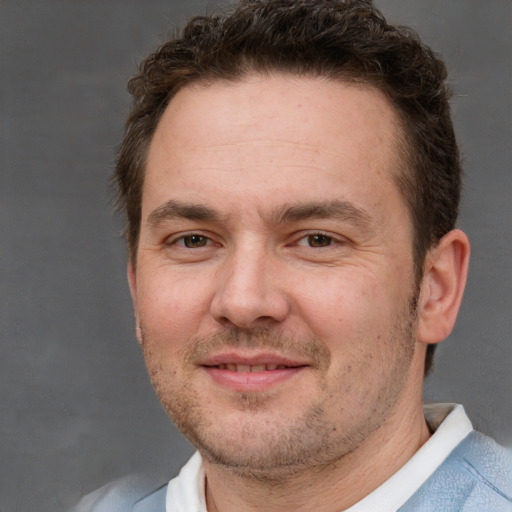 Joyful white adult male with short  brown hair and brown eyes