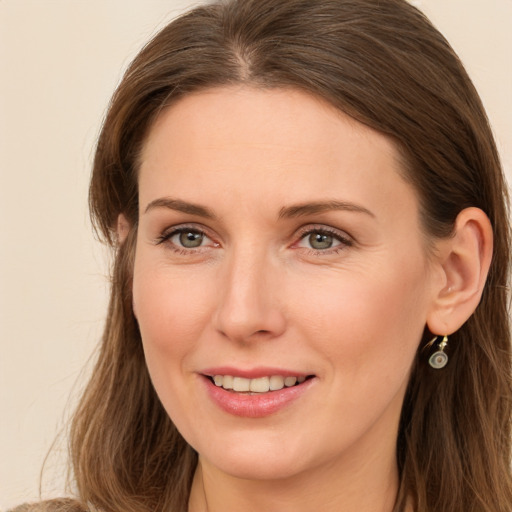 Joyful white young-adult female with long  brown hair and green eyes