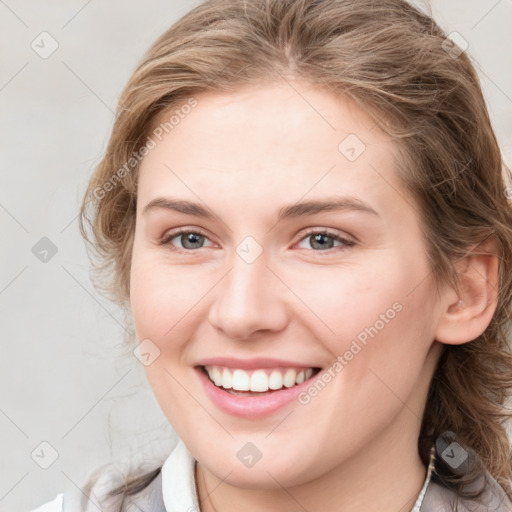 Joyful white young-adult female with long  brown hair and blue eyes