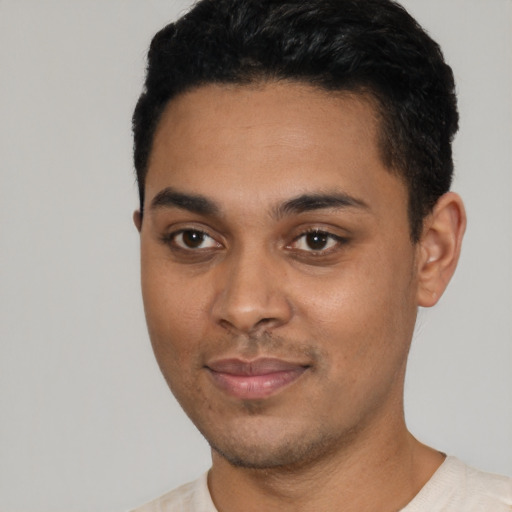 Joyful latino young-adult male with short  black hair and brown eyes
