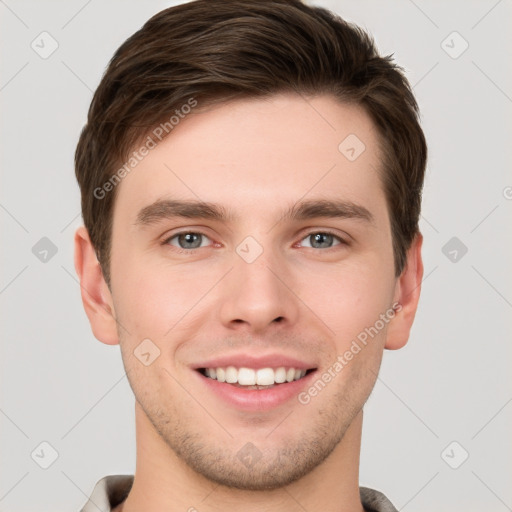 Joyful white young-adult male with short  brown hair and grey eyes