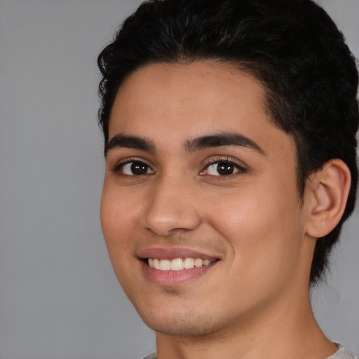 Joyful white young-adult male with short  black hair and brown eyes