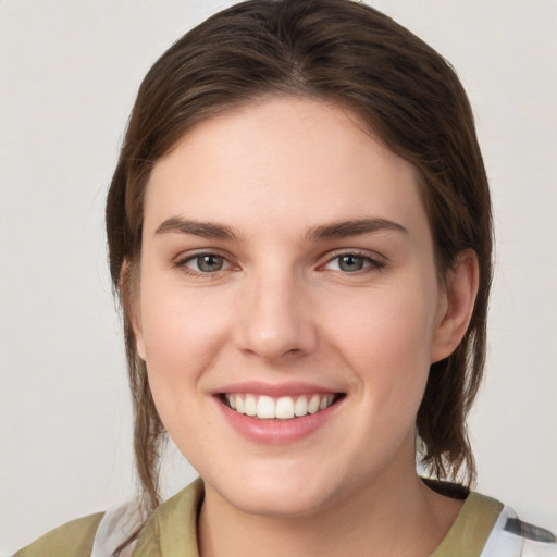 Joyful white young-adult female with medium  brown hair and grey eyes