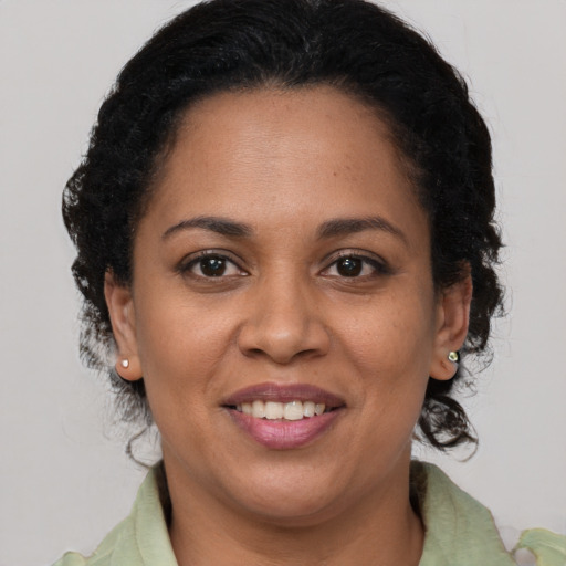 Joyful black adult female with medium  brown hair and brown eyes