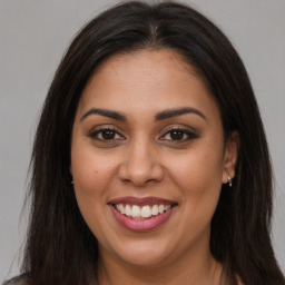 Joyful latino young-adult female with long  brown hair and brown eyes