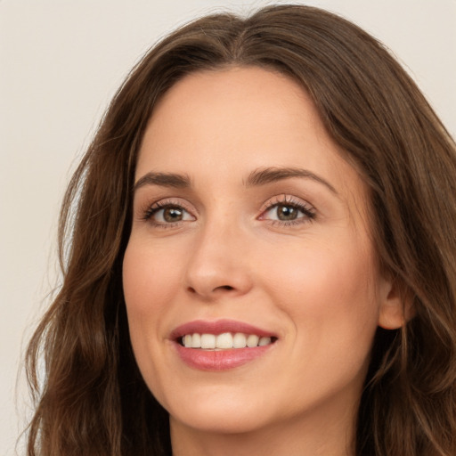 Joyful white young-adult female with long  brown hair and green eyes