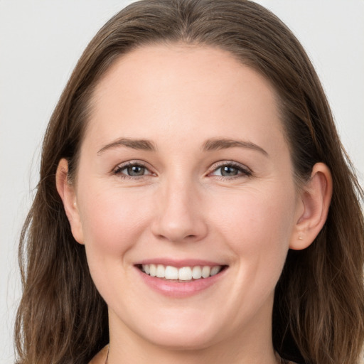 Joyful white young-adult female with long  brown hair and grey eyes