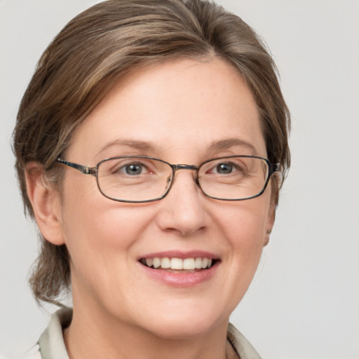 Joyful white adult female with medium  brown hair and grey eyes