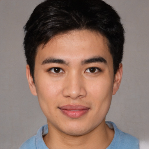 Joyful asian young-adult male with short  brown hair and brown eyes