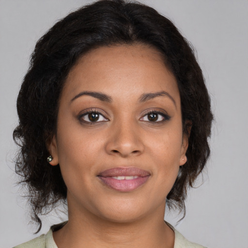 Joyful black young-adult female with medium  brown hair and brown eyes