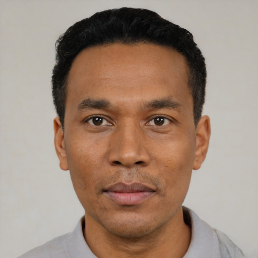 Joyful latino adult male with short  black hair and brown eyes