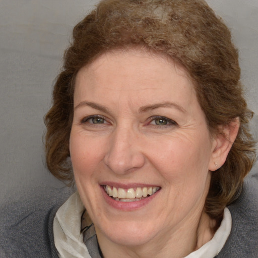 Joyful white adult female with medium  brown hair and blue eyes