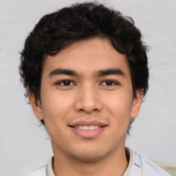 Joyful latino young-adult male with short  brown hair and brown eyes