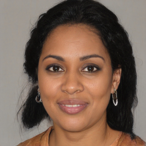 Joyful black young-adult female with long  black hair and brown eyes