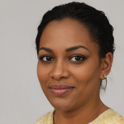 Joyful black young-adult female with short  black hair and brown eyes