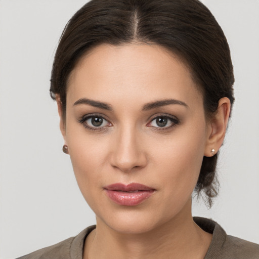 Joyful white young-adult female with long  brown hair and brown eyes