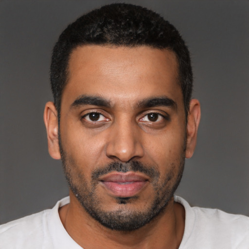 Joyful black young-adult male with short  black hair and brown eyes