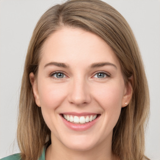 Joyful white young-adult female with long  brown hair and grey eyes