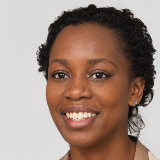 Joyful black young-adult female with long  black hair and brown eyes