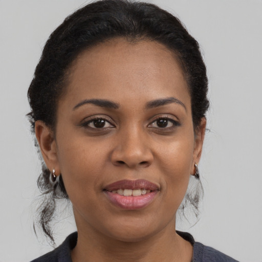 Joyful black young-adult female with medium  brown hair and brown eyes