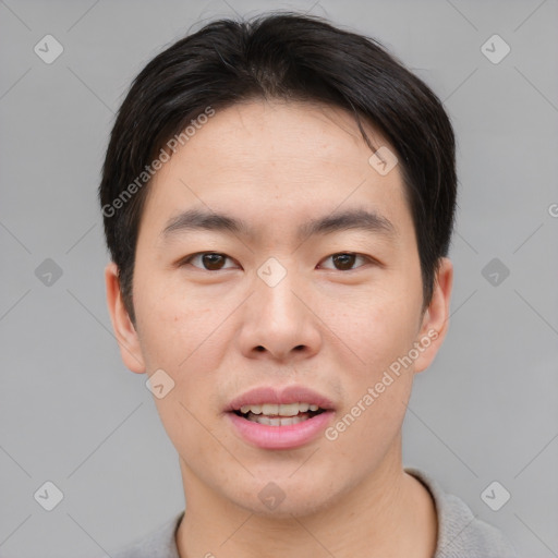 Joyful asian young-adult male with short  brown hair and brown eyes