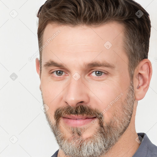 Joyful white adult male with short  brown hair and grey eyes