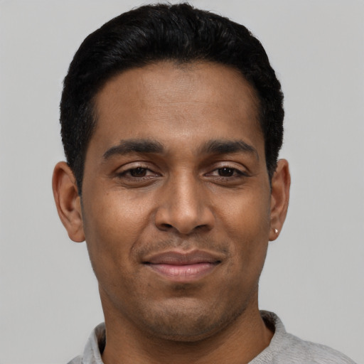 Joyful latino young-adult male with short  black hair and brown eyes