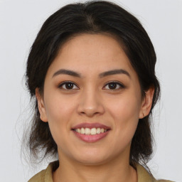 Joyful latino young-adult female with medium  brown hair and brown eyes