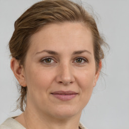 Joyful white adult female with medium  brown hair and grey eyes