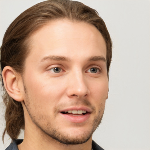 Joyful white young-adult male with short  brown hair and grey eyes