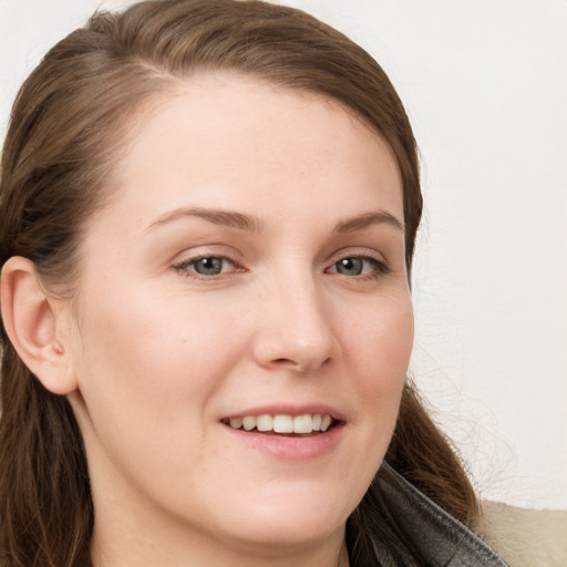 Joyful white young-adult female with long  brown hair and blue eyes