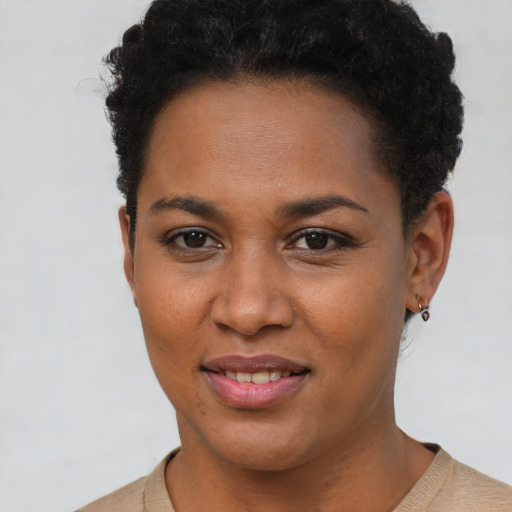 Joyful black young-adult female with short  brown hair and brown eyes