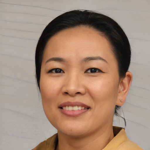 Joyful asian young-adult female with medium  brown hair and brown eyes