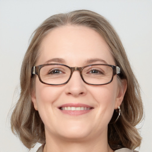 Joyful white adult female with medium  brown hair and blue eyes